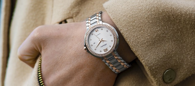 main dans la poche avec montre dorée au poignet