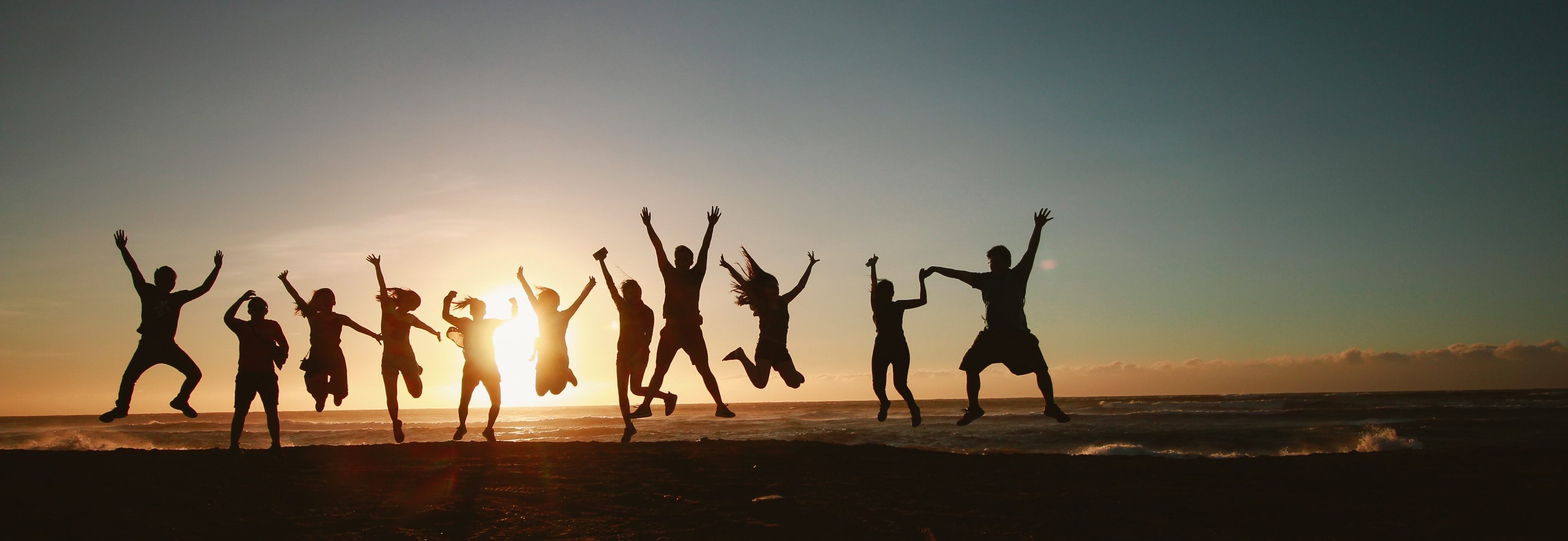 Groupe de gens qui sautent sur la plage