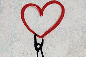 Coeur rouge dessiné sur un mur de béton blanc