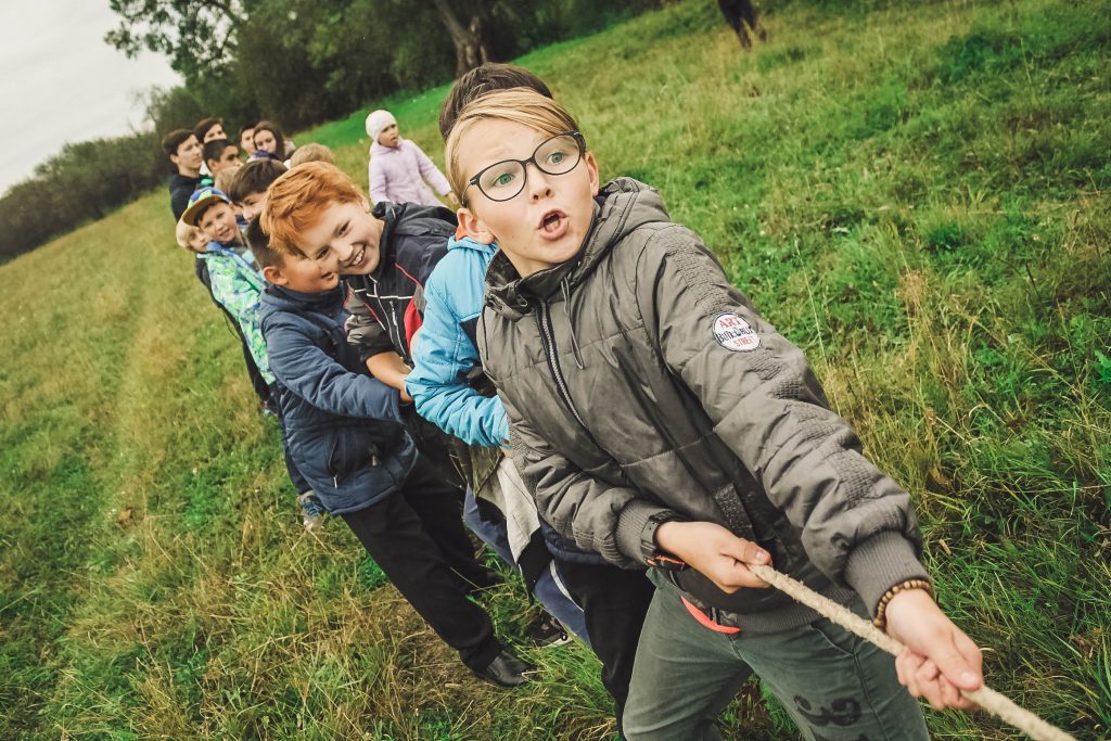 groupe d'enfants qui tirent sur une corde. jeu d'extérieur sur une pelouse